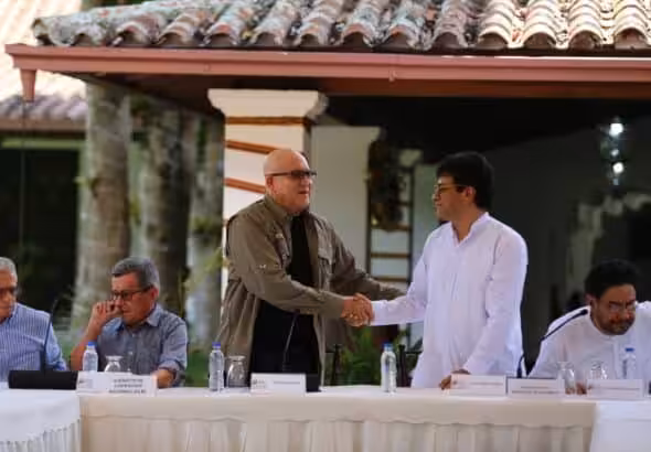 Heads of the delegations of Colombian government and ELN shake hands as they sit down to sign an agreement to restart the Colombian peace talks, in Caracas, on October 4, 2022. Photo: VTV.