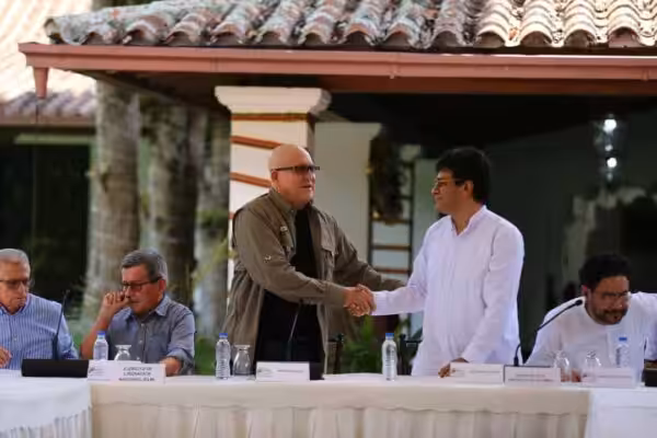 Heads of the delegations of Colombian government and ELN shake hands as they sit down to sign an agreement to restart the Colombian peace talks, in Caracas, on October 4, 2022. Photo: VTV.