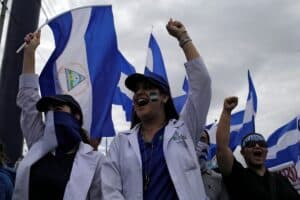 Doctors raise their fist triumphantly grasping the Nicaraguan flag. Photo: The Lancet