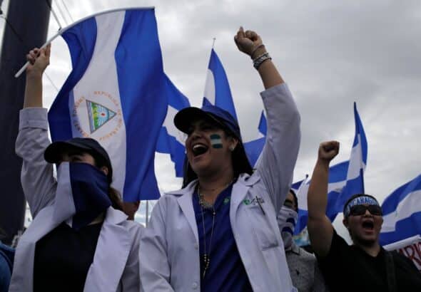 Doctors raise their fist triumphantly grasping the Nicaraguan flag. Photo: The Lancet