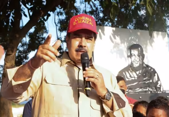 Venezuelan President Nicolas Maduro during a recent visit to El Maizal commune, Lara state, with a drawing of Hugo Chávez behind him. Photo: Presidential Press.