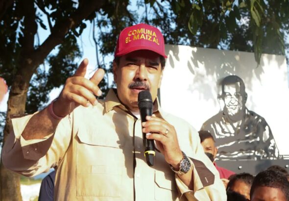 Venezuelan President Nicolas Maduro during a recent visit to El Maizal commune, Lara state, with a drawing of Hugo Chávez behind him. Photo: Presidential Press.
