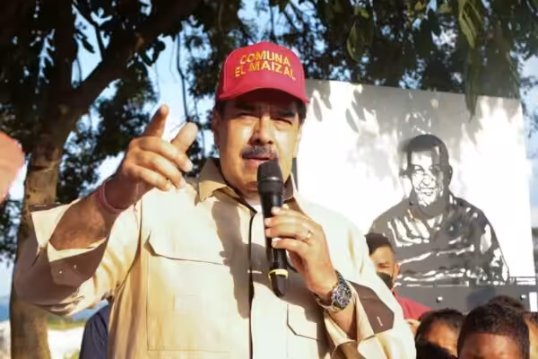 Venezuelan President Nicolas Maduro during a recent visit to El Maizal commune, Lara state, with a drawing of Hugo Chávez behind him. Photo: Presidential Press.