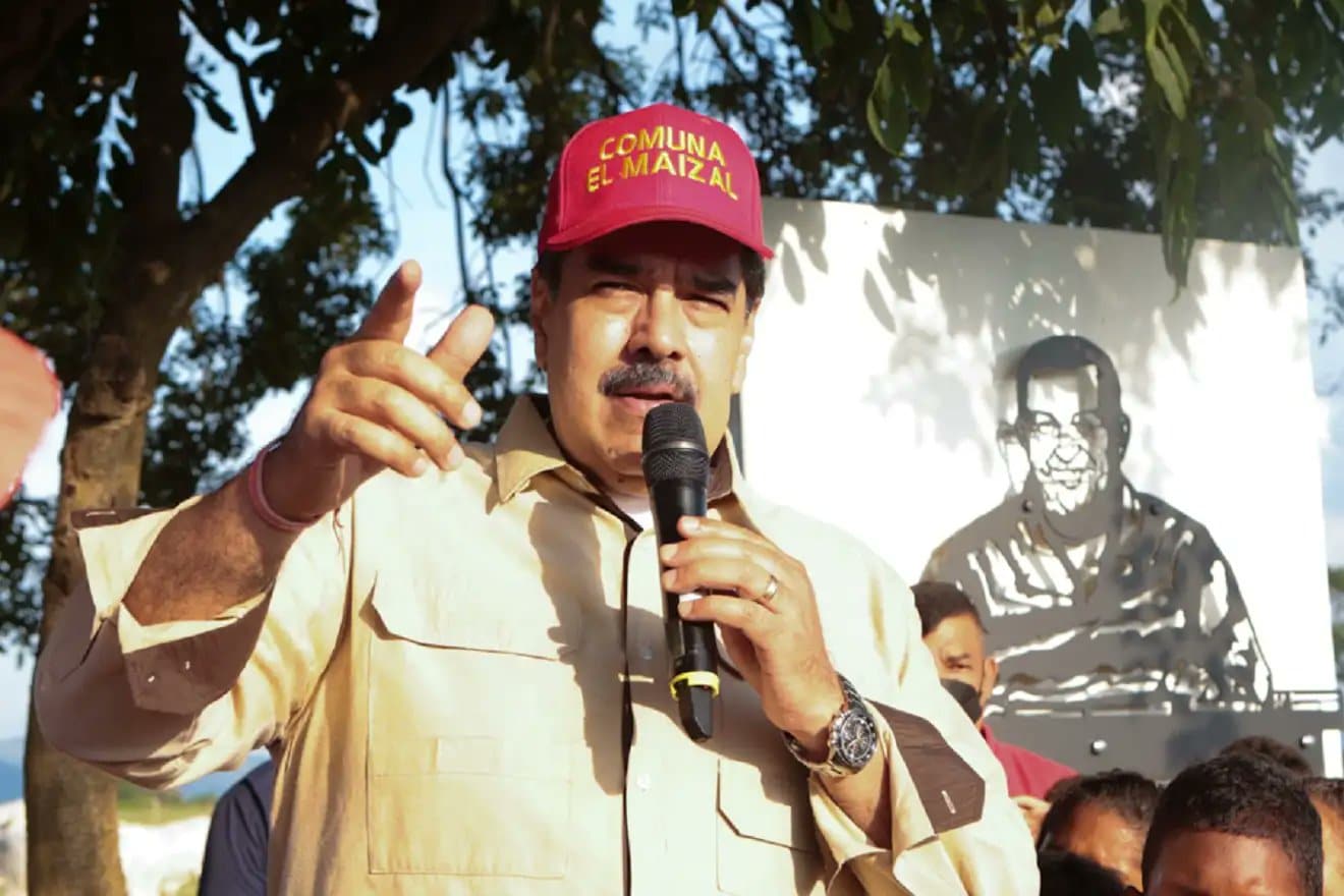 Venezuelan President Nicolas Maduro during a recent visit to El Maizal commune, Lara state, with a drawing of Hugo Chávez behind him. Photo: Presidential Press.