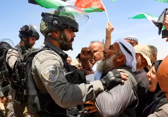 Israeli soldiers confront Palestinians in Masafer Yatta protesting against a court order that allows the Israeli occupation to demolish Palestinian homes to build illegal settlements. Photo: AFP/Hazem Bardel.