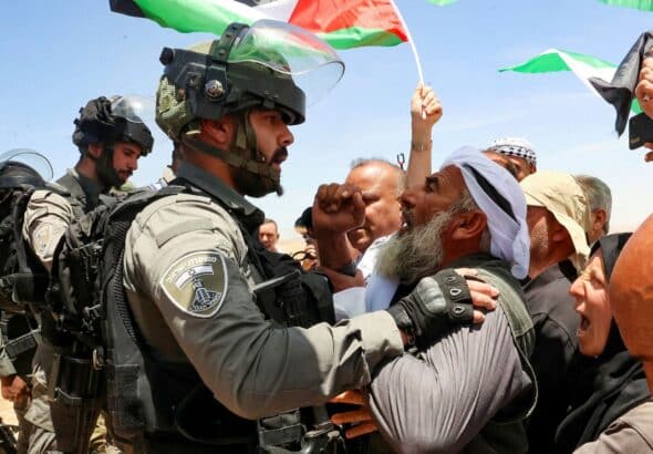 Israeli soldiers confront Palestinians in Masafer Yatta protesting against a court order that allows the Israeli occupation to demolish Palestinian homes to build illegal settlements. Photo: AFP/Hazem Bardel.