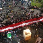 Protesters raise the red and white banners of the Peruvian flag during the "Taking of Lima" in support of President Castillo. Photo: El Comercio.