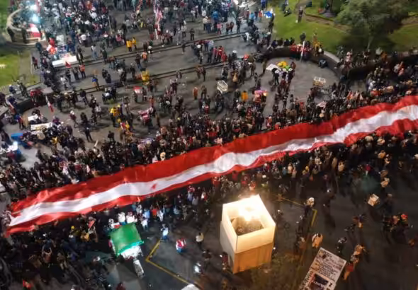 Protesters raise the red and white banners of the Peruvian flag during the "Taking of Lima" in support of President Castillo. Photo: El Comercio.
