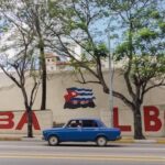 A person and a driver passing by a graffiti that says "Cuba Libre". Photo: Yerson Olivares.