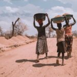 Two black women and a girl carrying bowl on their heads. Photo: Ninno Jack Jr.