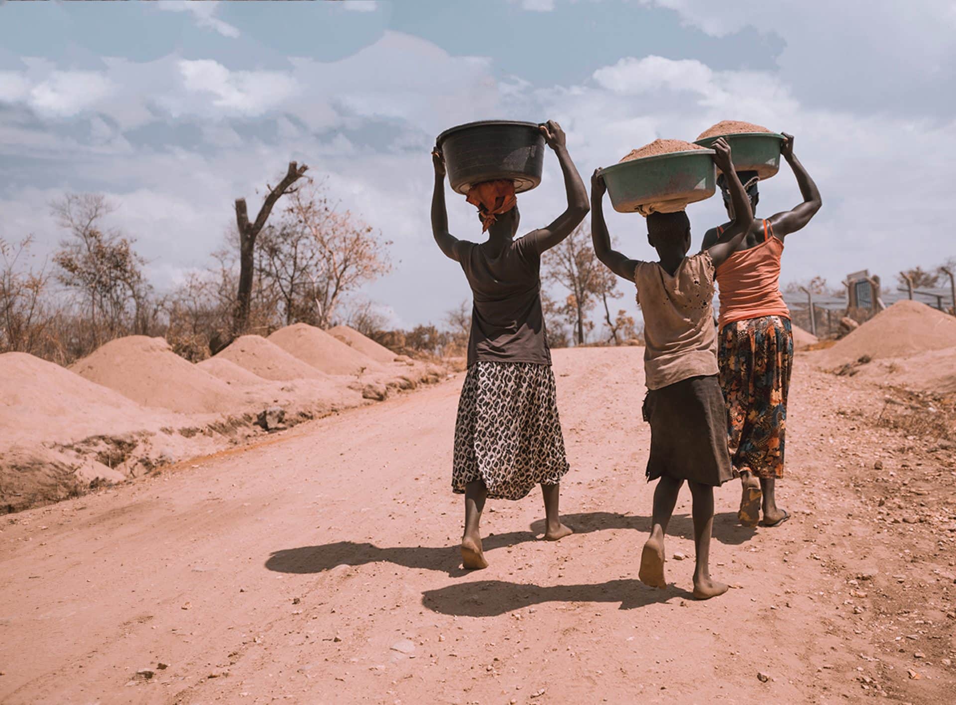 Two black women and a girl carrying bowl on their heads. Photo: Ninno Jack Jr.