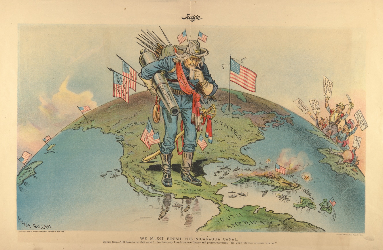 Early 20th century cartoon depicting an “Uncle Sam” carrying a cannon and multiple US flags, stepping over Texas in a map of the hemisphere, and looking down to Central and South America in a reflexive way. Cartoon by Victor Guillam/Cornell University.