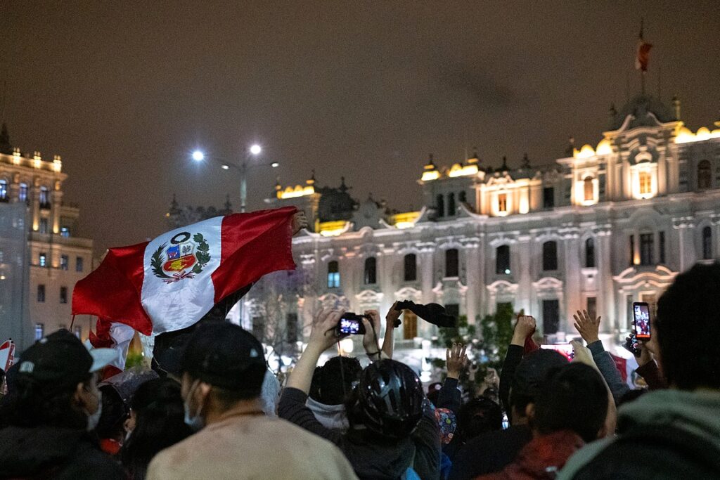 Demonstrations at Plaza San MartĂn, protesters carrying a large Peruvian flag. Photo: Samantha Hare.
