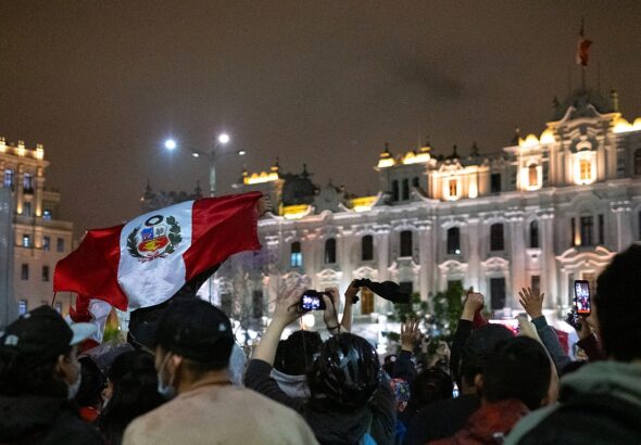 Demonstrations at Plaza San Martín, protesters carrying a large Peruvian flag. Photo: Samantha Hare.