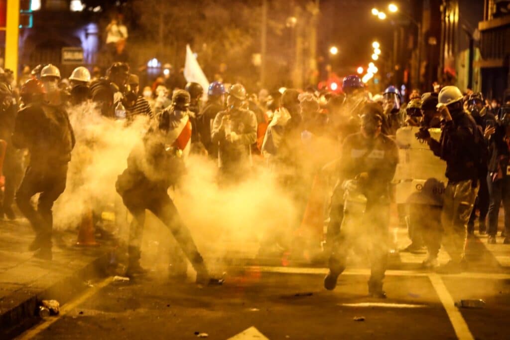Night-time clashes between Peruvian protesters and the police forces, surrounded by tear gas. Photo: Peru21.