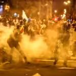 Night-time clashes between Peruvian protesters and the police forces, surrounded by tear gas. Photo: Peru21.