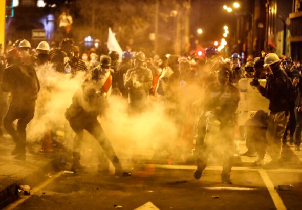Night-time clashes between Peruvian protesters and the police forces, surrounded by tear gas. Photo: Peru21.