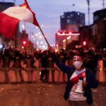 Peruvian protester stands in defiance of the police. Photo: Alessandro Cinque.