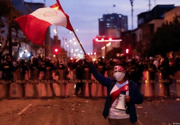 Peruvian protester stands in defiance of the police. Photo: Alessandro Cinque.