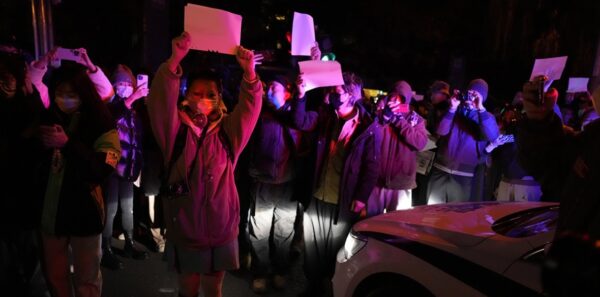 Protesters hold up blank papers and chant slogans as they march in protest in Beijing, Sunday, November 27, 2022. Photo: Morning Star. 