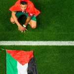Morocco’s Abdelhamid Sabiri celebrates, sitting by the Palestinian flag, after the World Cup round of 16 soccer match between Morocco and Spain, at the Education City Stadium in Al Rayyan, Qatar, Dec. 6, 2022. Photo: Petr David Josek, AP.
