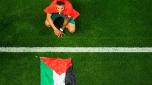 Morocco’s Abdelhamid Sabiri celebrates, sitting by the Palestinian flag, after the World Cup round of 16 soccer match between Morocco and Spain, at the Education City Stadium in Al Rayyan, Qatar, Dec. 6, 2022. Photo: Petr David Josek, AP.