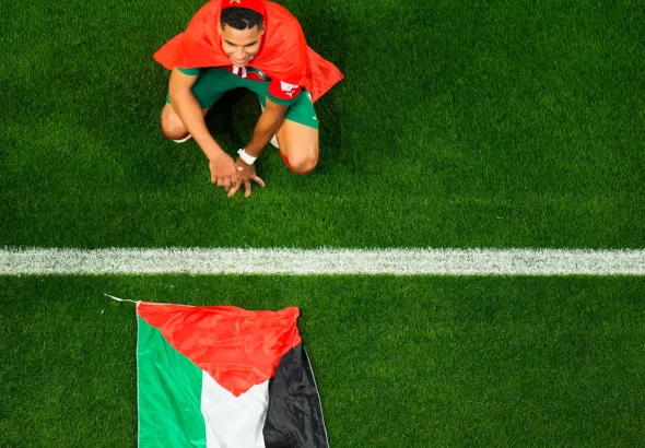 Morocco’s Abdelhamid Sabiri celebrates, sitting by the Palestinian flag, after the World Cup round of 16 soccer match between Morocco and Spain, at the Education City Stadium in Al Rayyan, Qatar, Dec. 6, 2022. Photo: Petr David Josek, AP.