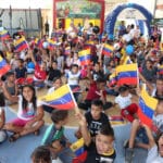 Venezuelan kids holding the Venezuelan flag in a toy delivery event. Photo: Ultimas Noticias.