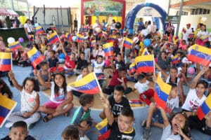 Venezuelan kids holding the Venezuelan flag in a toy delivery event. Photo: Ultimas Noticias.