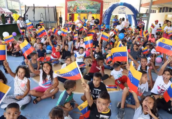 Venezuelan kids holding the Venezuelan flag in a toy delivery event. Photo: Ultimas Noticias.