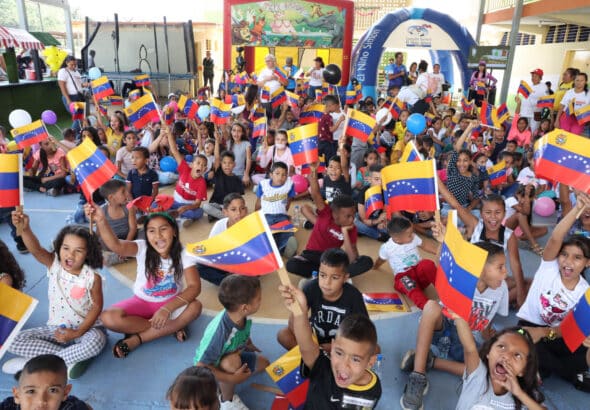 Venezuelan kids holding the Venezuelan flag in a toy delivery event. Photo: Ultimas Noticias.