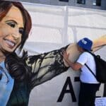 A supporter of Cristina Fernández de Kirchner kisses a banner of the vice-president hung outside the courthouse in Buenos Aires on Tuesday, December 6, 2022. Photo: AFP/Getty Images.