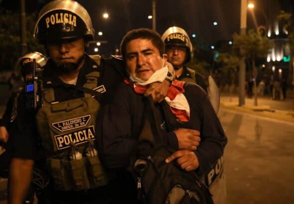 Police detain an activist calling for the return of deposed president Pedro Castillo. Photo: Juan Zapata.