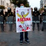 A man holds up a sign with the likeness of President Dina Boluarte that reads, "Murderer." For the sixth day in a row, hundreds of people demonstrated through the main streets of Lima to demand the release of former President Castillo and the closure of the Peruvian Congress. Lucas Aguayo Araos/picture alliance via Getty Images.