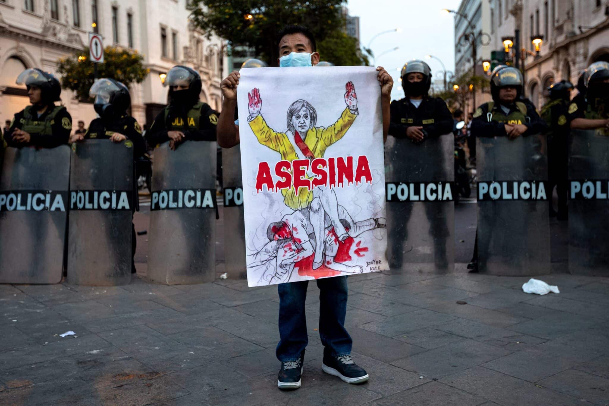 A man holds up a sign with the likeness of President Dina Boluarte that reads, "Murderer." For the sixth day in a row, hundreds of people demonstrated through the main streets of Lima to demand the release of former President Castillo and the closure of the Peruvian Congress. Lucas Aguayo Araos/picture alliance via Getty Images.