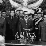 Dictator Jorge Rafael Videla (center) is sworn in as president of the military junta in Argentina in 1976. File photo from Wikimedia Commons.
