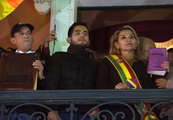 Jeanine Añez, after proclaiming herself de facto president of Bolivia, with a bible in her hand. Luis Fernando Camacho is next to her (left) holding a bigger bible. Photo: PA Images.