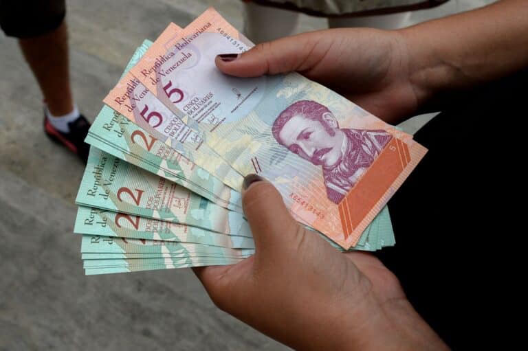 A woman holding bolivar notes in downtown Caracas. Photo: Federico Parra for Getty Images.