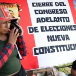 Protesters camping in Lima with a big banner in the back resembling the Peruvian flag with a caption that reads: "dissolution of Congress, early elections, new constitution." Photo: Telemundo.