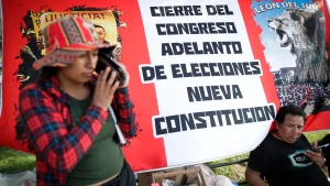 Protesters camping in Lima with a big banner in the back resembling the Peruvian flag with a caption that reads: "dissolution of Congress, early elections, new constitution." Photo: Telemundo.