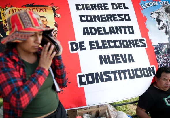 Protesters camping in Lima with a big banner in the back resembling the Peruvian flag with a caption that reads: "dissolution of Congress, early elections, new constitution." Photo: Telemundo.