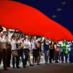 Protestors hold up large Venezuelan flag. Photo: Archive.