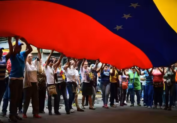 Protestors hold up large Venezuelan flag. Photo: Archive.