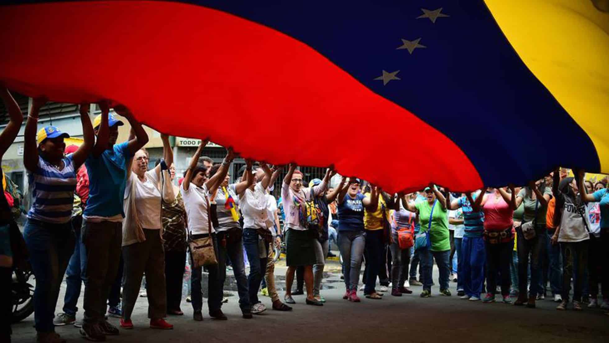 Protestors hold up large Venezuelan flag. Photo: Archive.