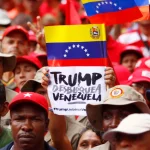 A demonstrator holds a sign with a message that reads in Spanish: “Trump unblock Venezuela” in Caracas, August 7, 2019. Photo: AP.