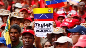 A demonstrator holds a sign with a message that reads in Spanish: “Trump unblock Venezuela” in Caracas, August 7, 2019. Photo: AP.
