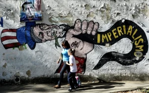 A woman and a girl walk in front of a graffiti of US Uncle Sam in Caracas on March 11, 2015. Photo: AFP/Federico Parra/Getty Images.