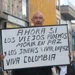 Protestor holding a sign stating: "Now if the old can die in peace and the young live in peace. Long Live Colombia." Photo: Alliance for Global Justice.