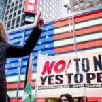 Claudia De La Cruz of The People's Forum speaks to a crowd outside of the US Army Recruiting Station in Times Square. Photo: Peoples Dispatch.