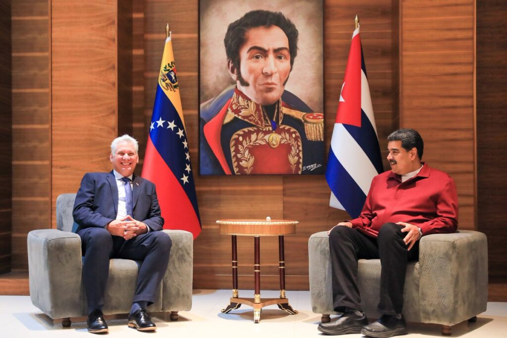Cuban President Miguel Díaz-Canel (left) and Venezuelan President Nicolás Maduro (right) with the country flags of their counterparts beside them and a drawing of Simón Bolívar in the background, during their meeting on Thursday, January 26. Photo: Presidential Press.